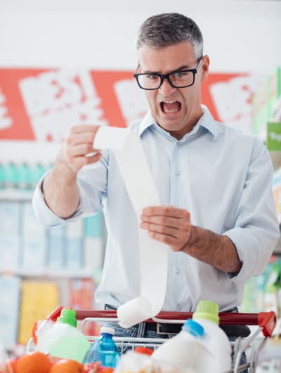 Man screaming and looking stressed while holding a long receipt