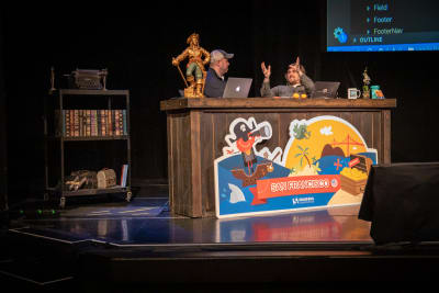 Chris Coyier and Brad Frost sitting at a desk on stage talking